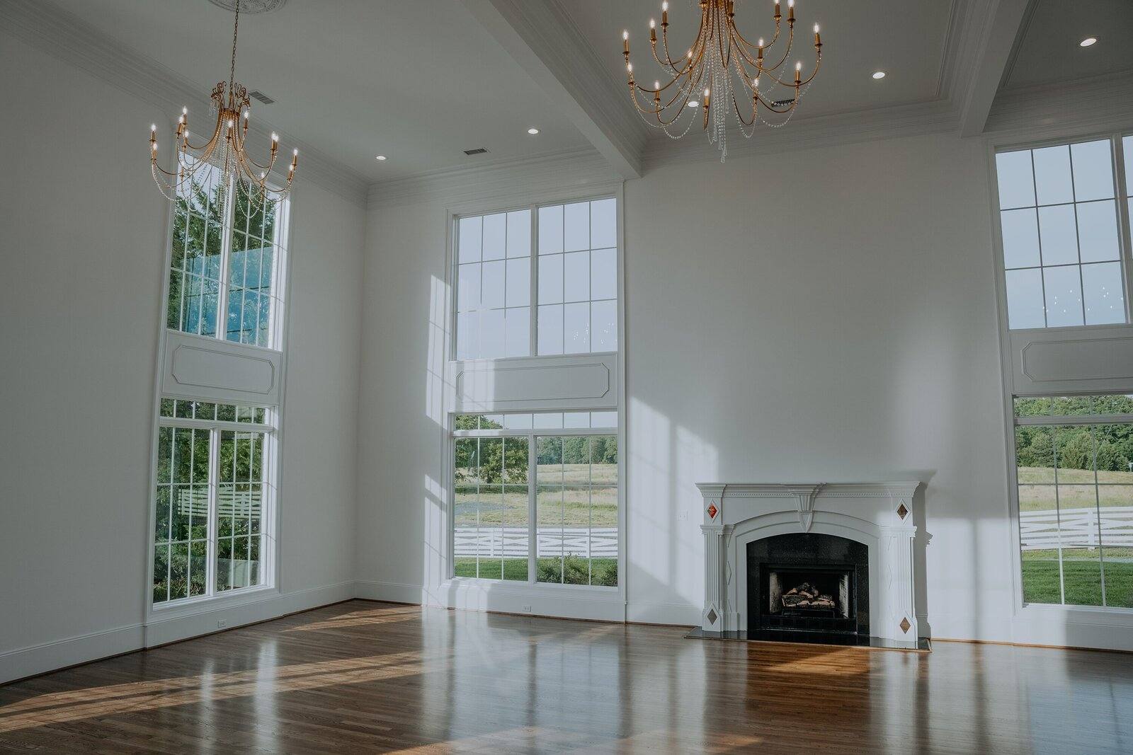 The empty ballroom with its tall windows and fireplace