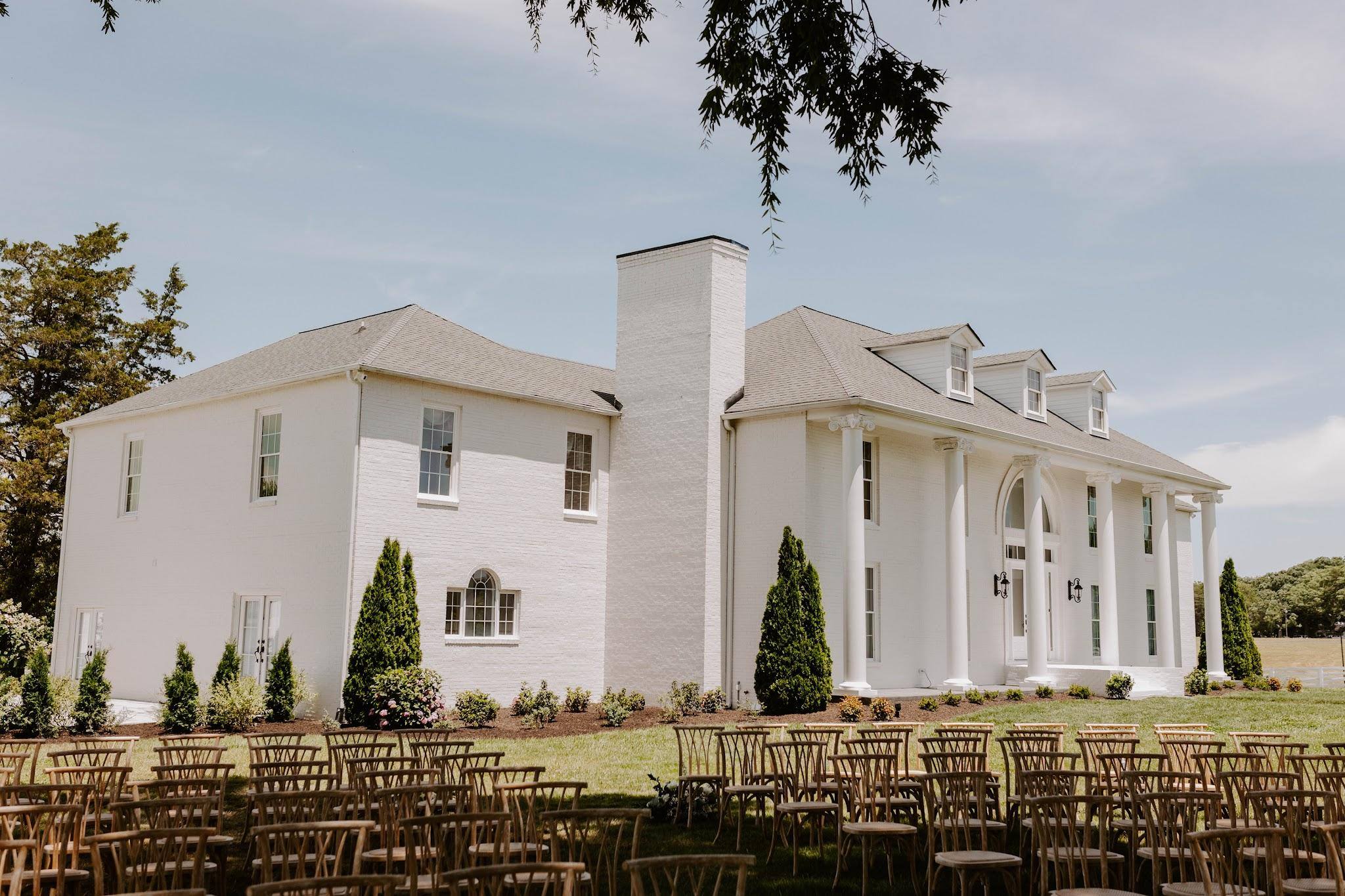 Ceremony chairs on the lawn beside the manor