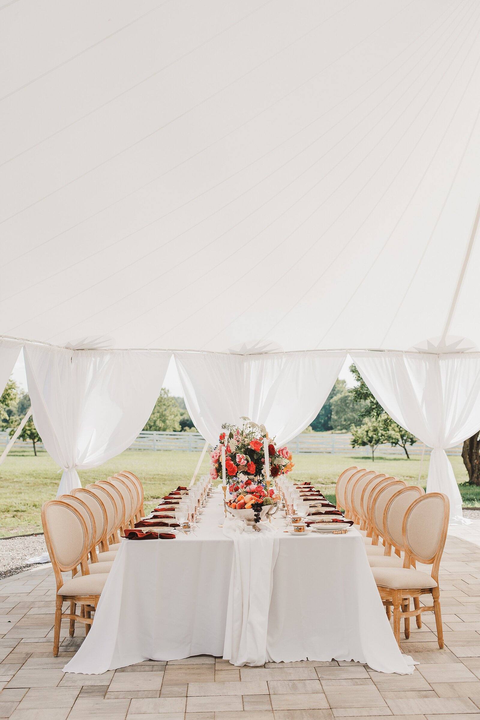 Reception tables set under the sailcloth tent